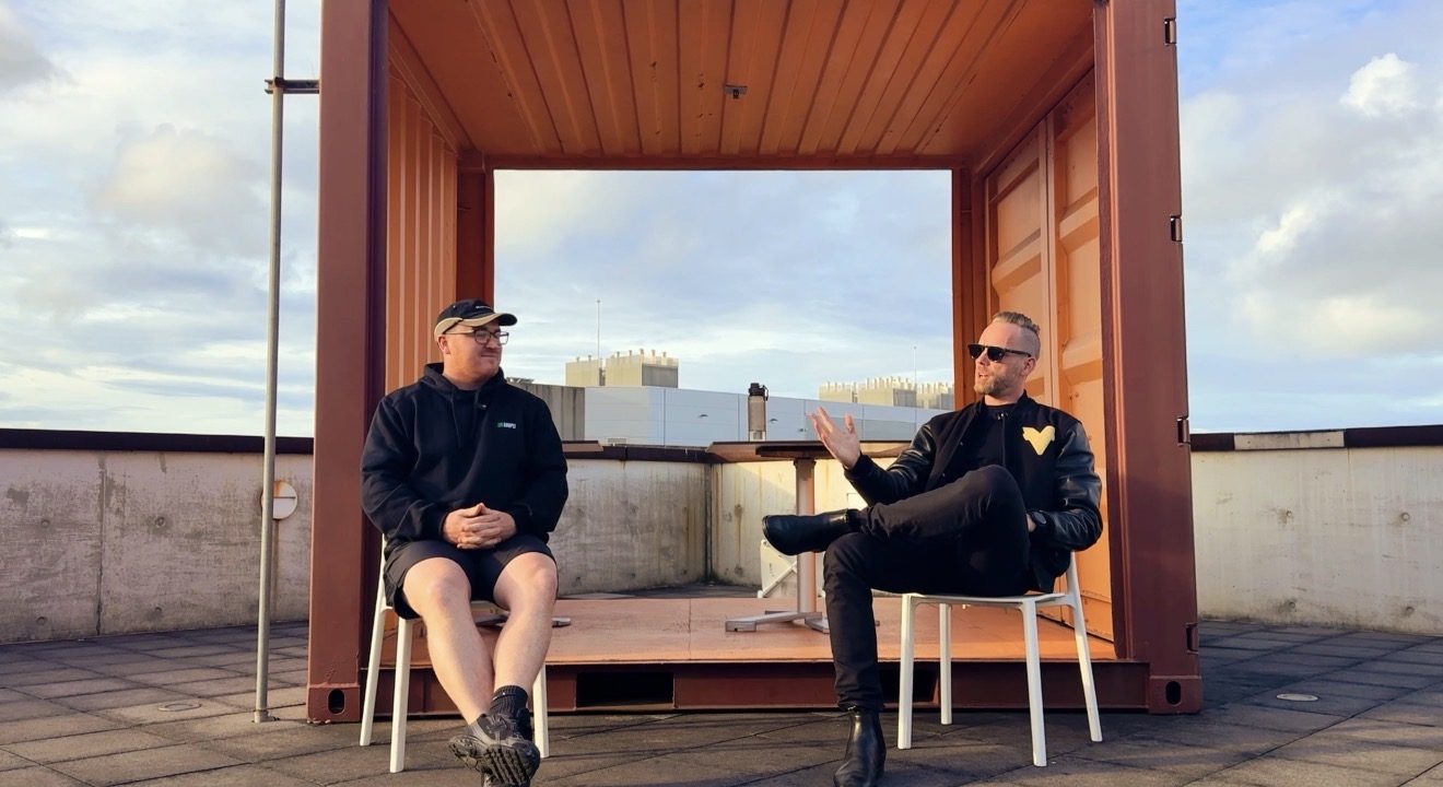 Mitch Catterall in conversation with a client on a rooftop at sunset